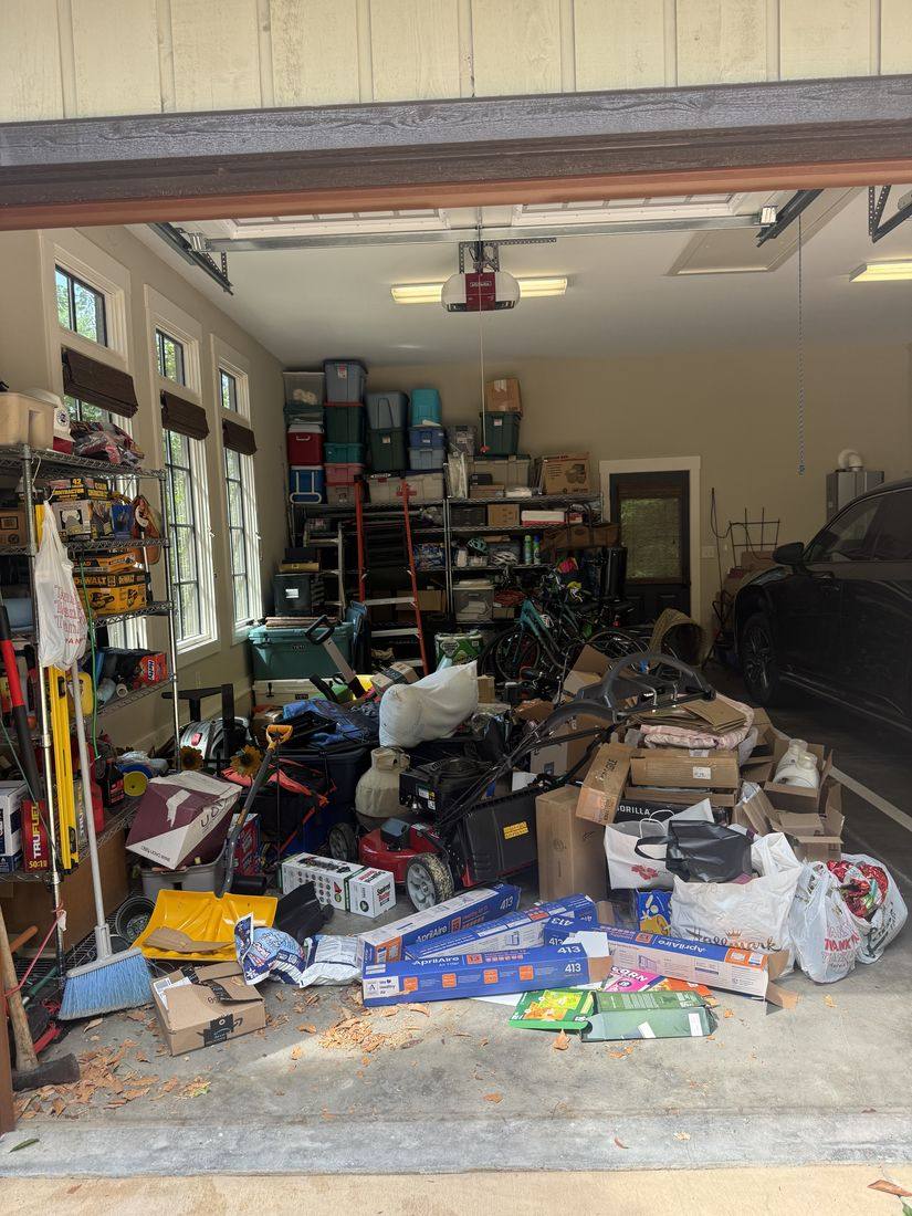 Cluttered garage before a Southern Panes transformation — boxes, equipment and junk covering the floor